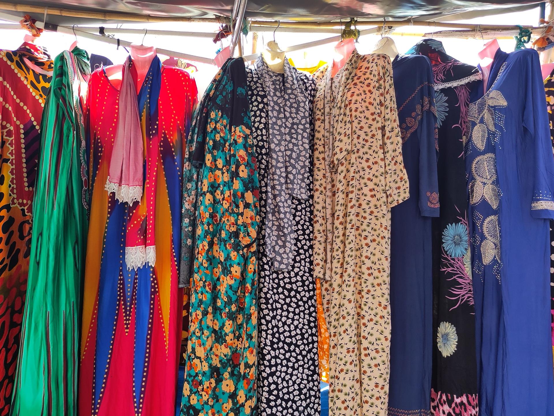 Des robes traditionnelles colorées pour femmes exposées sur un marché de rue au Sénégal
