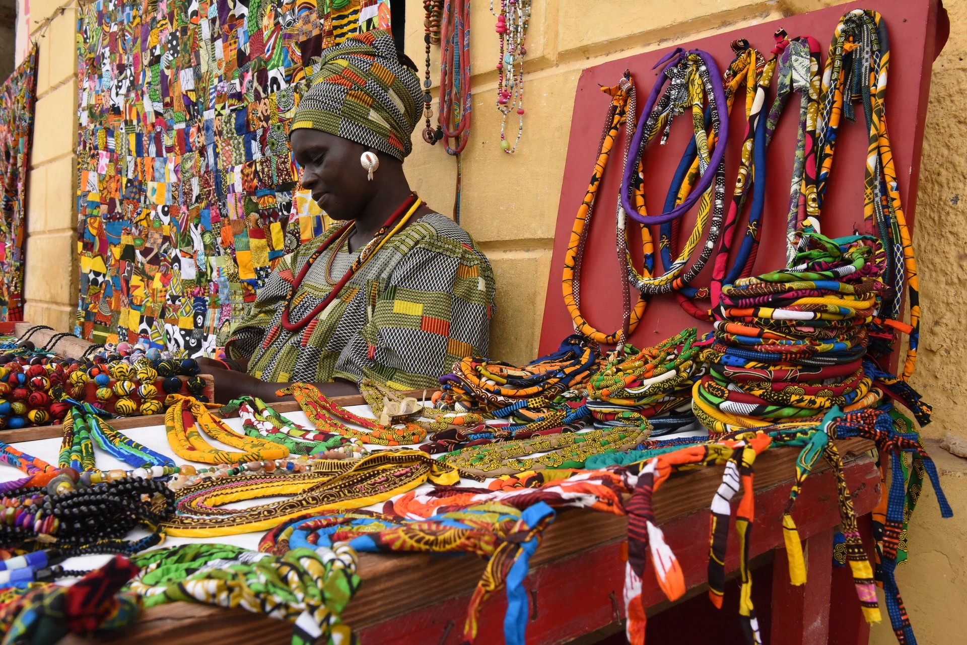 Femme adulte moyenne vendant des accessoires personnels colorés à l’étal du marché